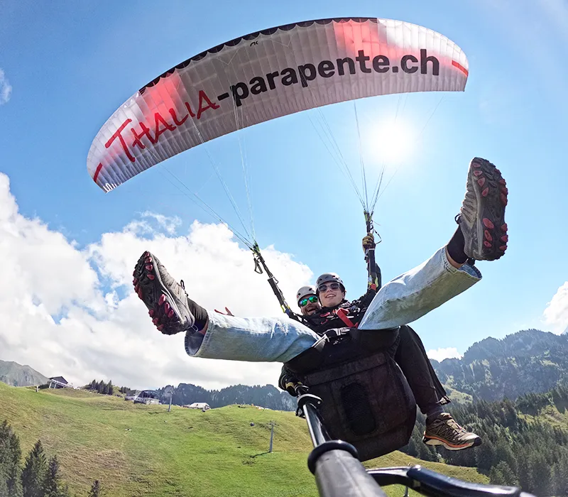 Passager souriant lors d'un baptême de parapente à Charmey (Gruyère) avec Thalia Parapente